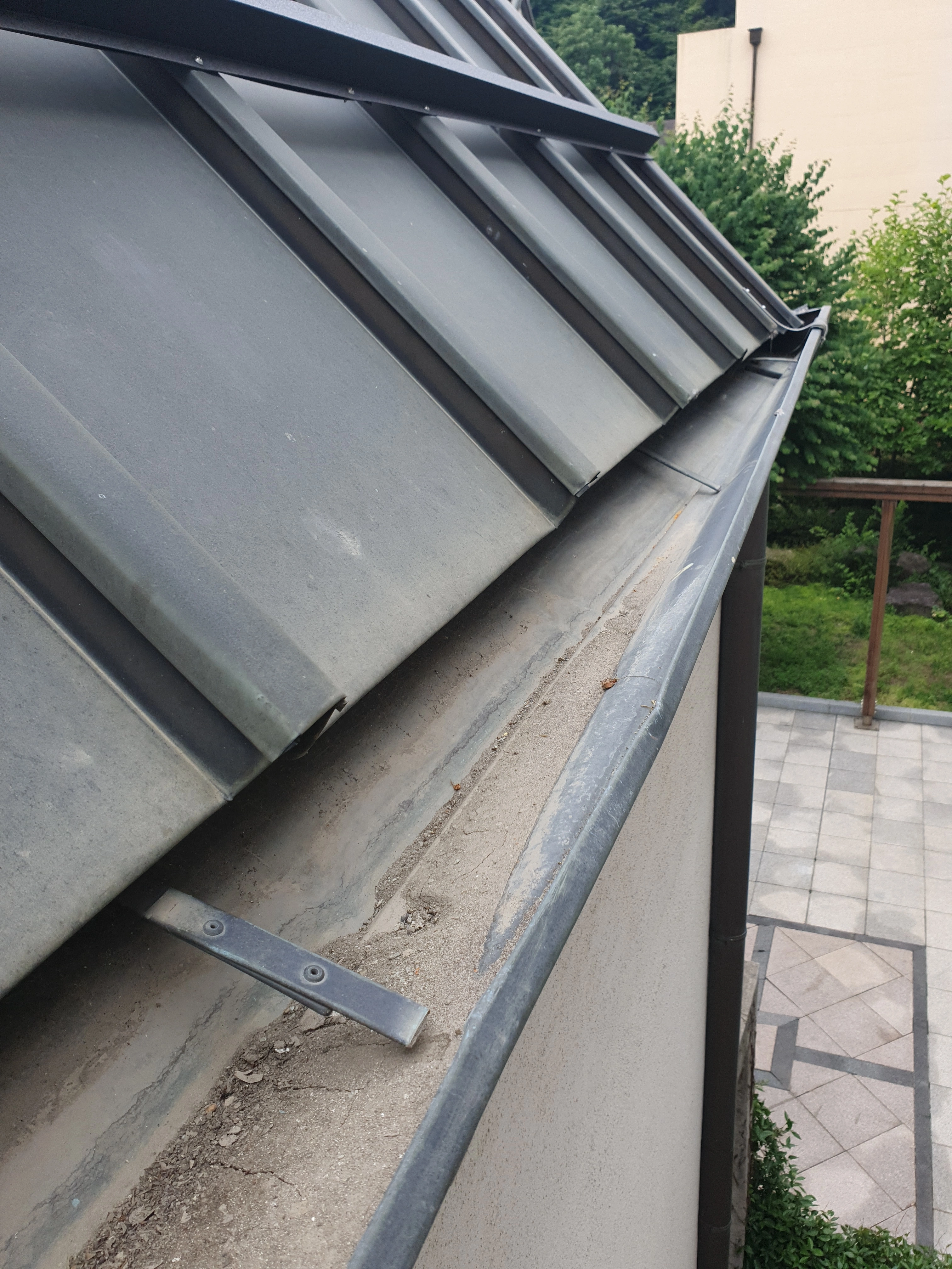 시공 전 — 낙엽망 없이 이물질이 쌓인 처마 홈통